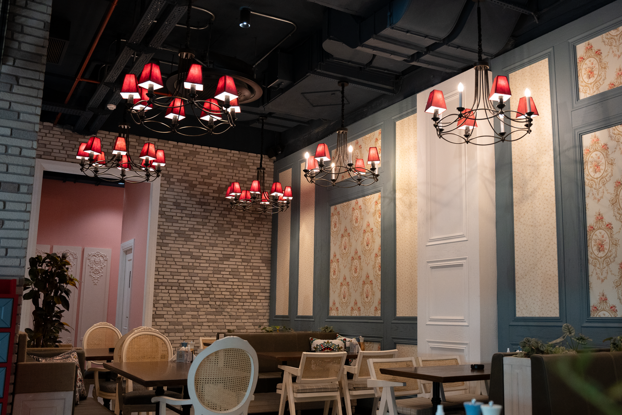 A beautifully designed cafe interior in Erbil, showcasing chandeliers and stylish furniture.