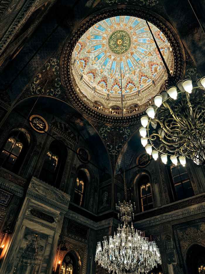Stunning architectural interior featuring an intricate dome and luxurious chandeliers in a historic building.